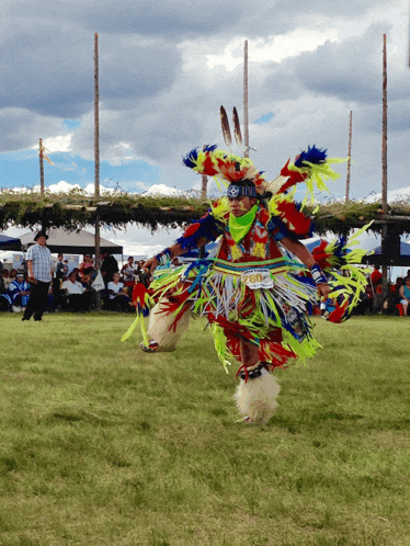 a man in a colorful native american costume has the number 700 on his waistband