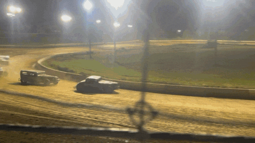 a race track with cars going around a curve at night
