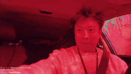 a man sitting in a car with a red background