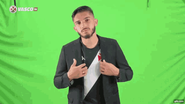 a man wearing a kappa shirt is standing in front of a green background