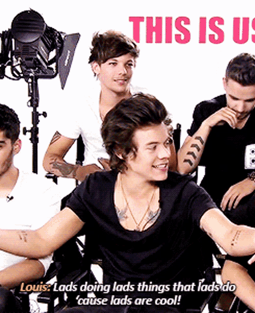 a group of men are sitting in front of a sign that says " this is us "