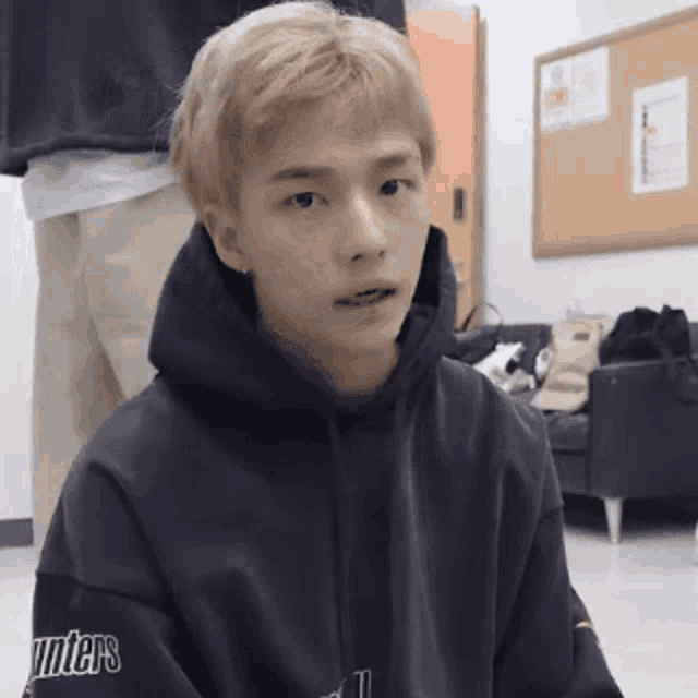 a young man wearing a black hoodie with unters on the sleeve