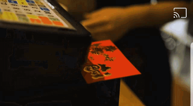 a red envelope with a chinese symbol on it sits on a counter next to a calculator