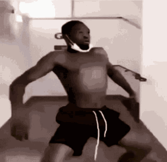a shirtless man wearing a mask is dancing