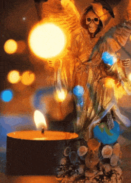 a statue of grim reaper with a candle in front of it