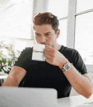 a man drinking from a cup that says appmart on it