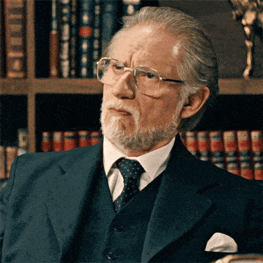 a man with glasses and a beard looks at the camera
