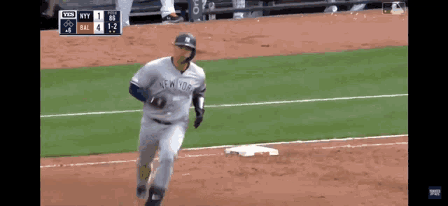 a baseball player for the new york yankees is running towards home plate
