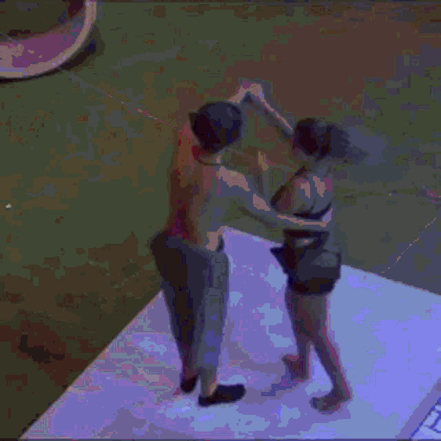 a man in a cowboy hat is dancing with a woman in a black top