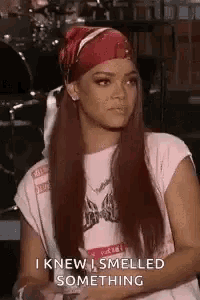 a woman wearing a bandana and a t-shirt is sitting in a room .