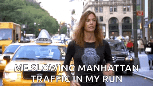 a woman is running down a city street with a taxi in the background and the words `` me slowing manhattan traffic in my run '' .