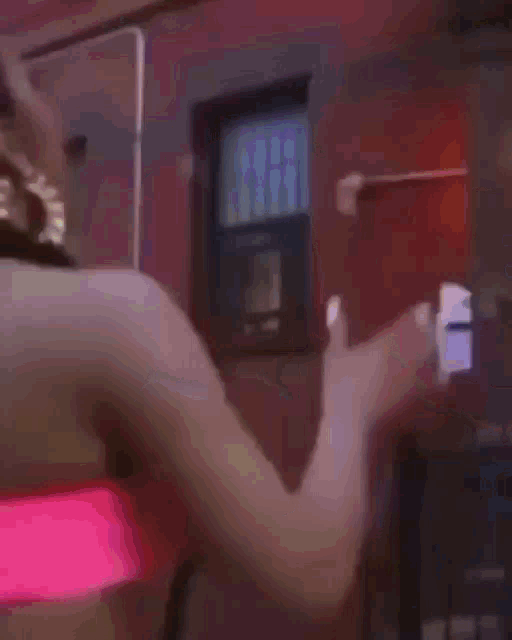 a woman in a pink bikini top is dancing with a man