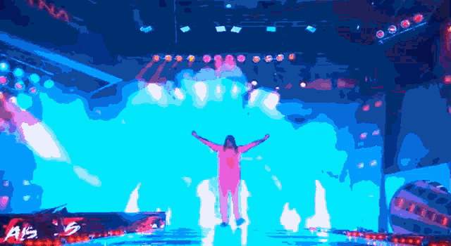 a man stands on a stage with his arms outstretched in front of a sign that says als