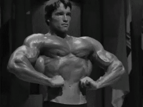 a black and white photo of arnold schwarzenegger flexing his muscles in a gym .