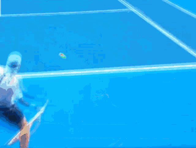 a blurred image of a tennis player on a blue court