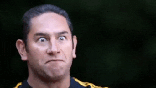 a man is making a funny face with his eyes closed .