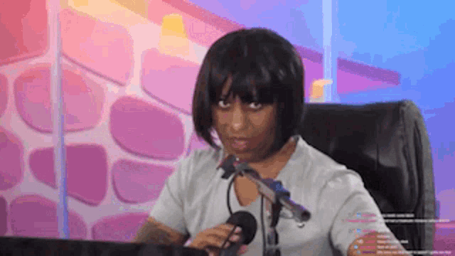 a woman is sitting in front of a microphone and making a funny face .
