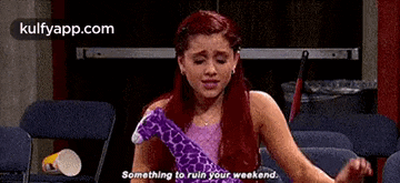 a girl with red hair is sitting in a chair holding a stuffed giraffe and saying `` something to ruin your weekend . ''
