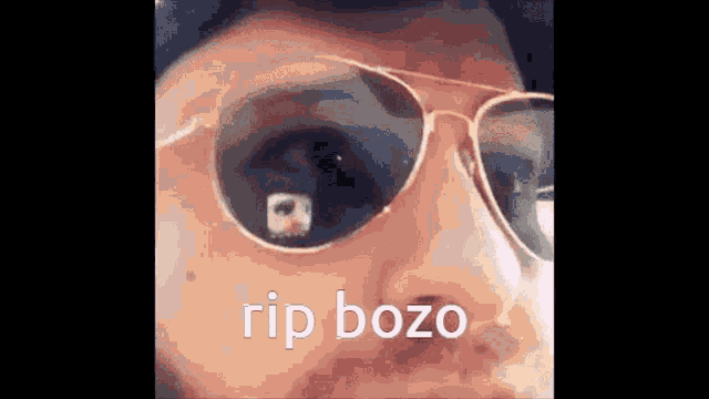 a close up of a person wearing sunglasses with the words rip bozo written on the bottom .