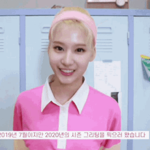 a woman wearing a pink shirt and a pink headband stands in front of lockers