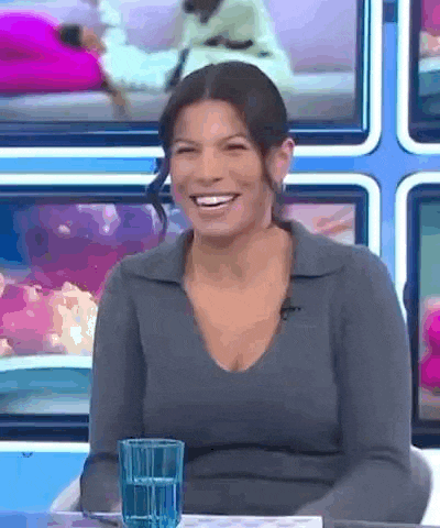 a woman is sitting at a table with a glass of water in front of her .
