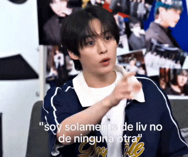 a young man in a blue jacket is pointing at the camera with the words " soy solamente de liv no de ninguna otra " written below him