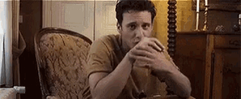 a man is sitting in a chair with his hands folded in front of his face .