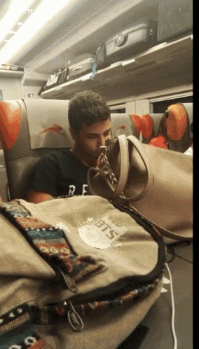 a man on a train with a bag that says bts
