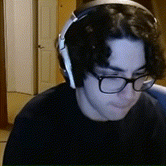 a man wearing glasses and headphones looks down at something
