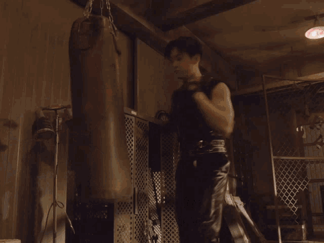 a man is standing next to a punching bag that says " it 's a little tough for the giant "