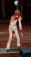 a man in a white suit and red gloves is standing on a stage .