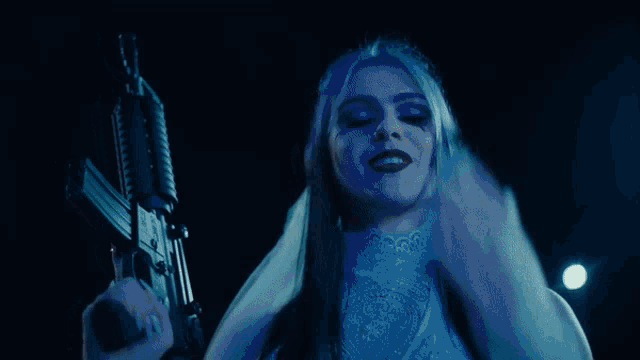 a woman in a white dress holds a gun in her hand