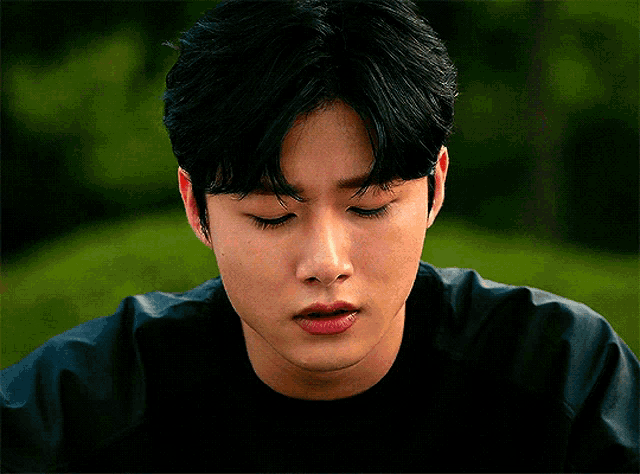 a close up of a young man 's face with a black shirt on