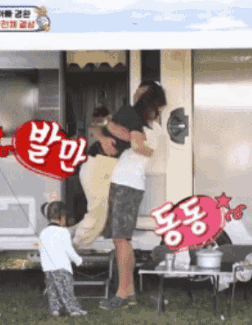 a man is carrying a woman in his arms in front of a trailer