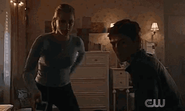 two people are standing next to each other in a room .