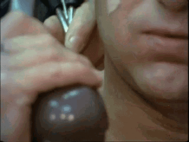 a close up of a man 's face while talking on a phone