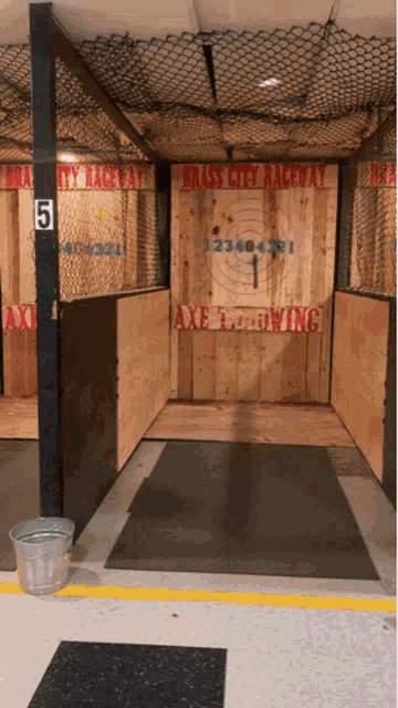 a room with a sign that says brass city raceway axe throwing