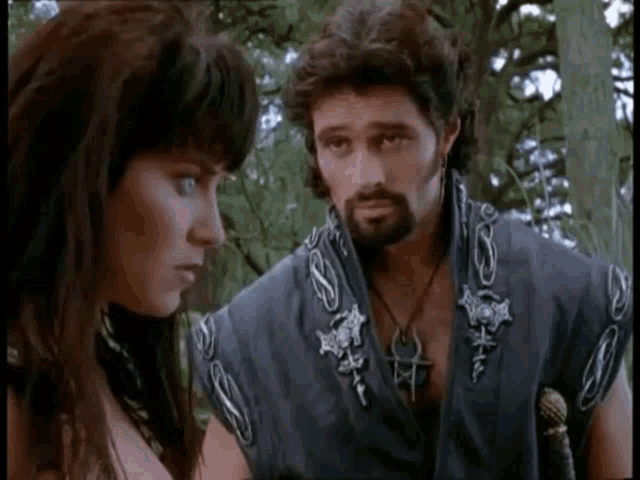 a man and a woman are standing next to each other and looking at each other .