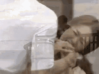 a man is holding a woman 's hand while she drinks from a glass of water .