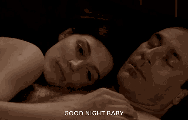a man and a woman are laying on a bed with the words good night baby below them