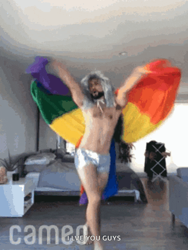 a shirtless man is dancing in front of a rainbow flag and the words cameo i love you guys
