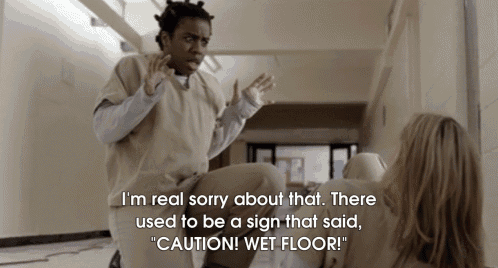 a woman is laying on the floor with a sign that says " caution wet floor "