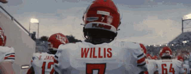 a football player wearing a white jersey with the name willis on it is standing on a field .