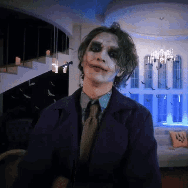 a man in a joker costume is standing in a room with bats hanging from the ceiling