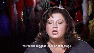a woman says " you 're the biggest loser on that stage " in front of a crowd