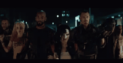 a group of people are standing in a dark room holding guns .