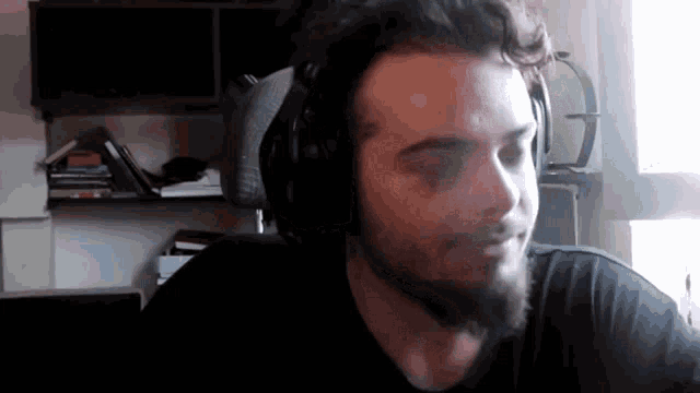 a man with a beard is wearing headphones and a microphone