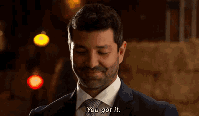a man in a suit and tie is smiling and saying you got it