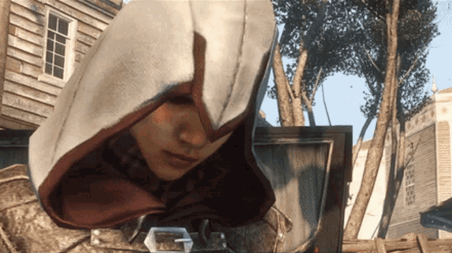 a man in a hooded jacket is looking down at something