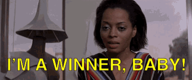 a woman says i 'm a winner baby in front of a statue